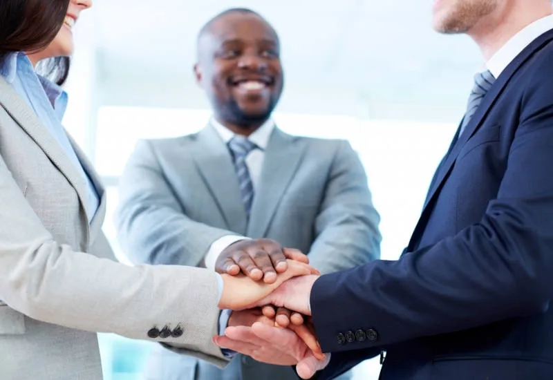 divorce mediation concept with mediator joining hands with couple